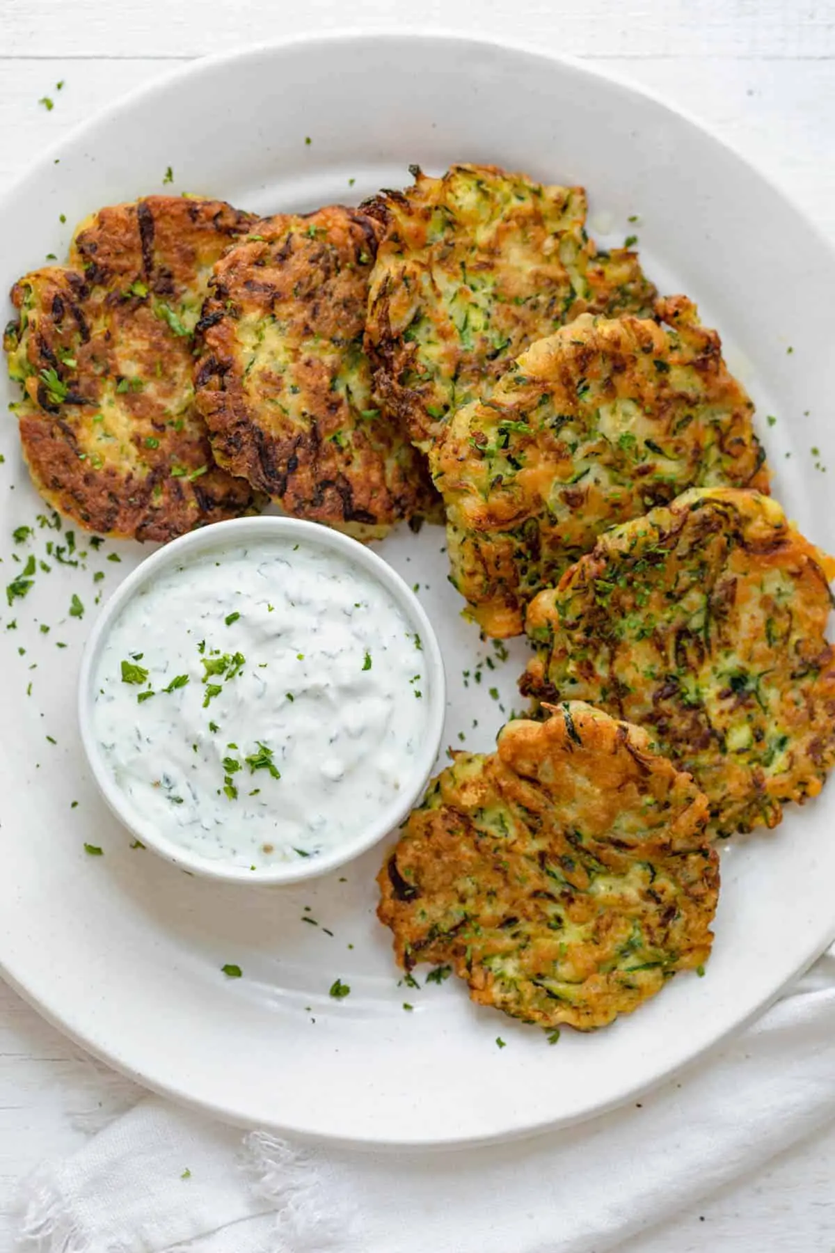 crispy zucchini fritters on a white plate