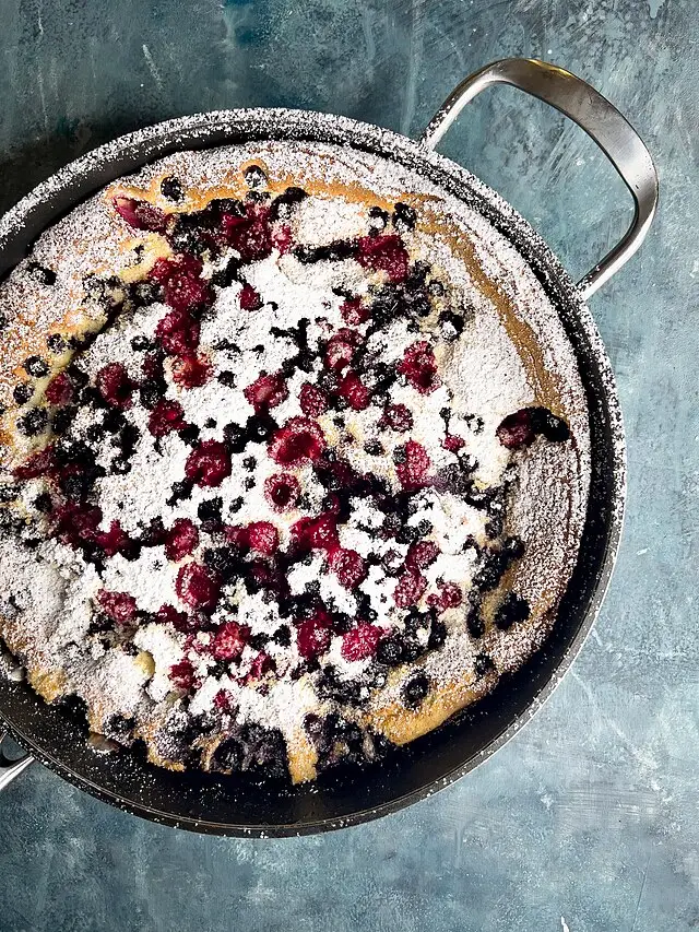 dutch baby with berries and powdered sugar