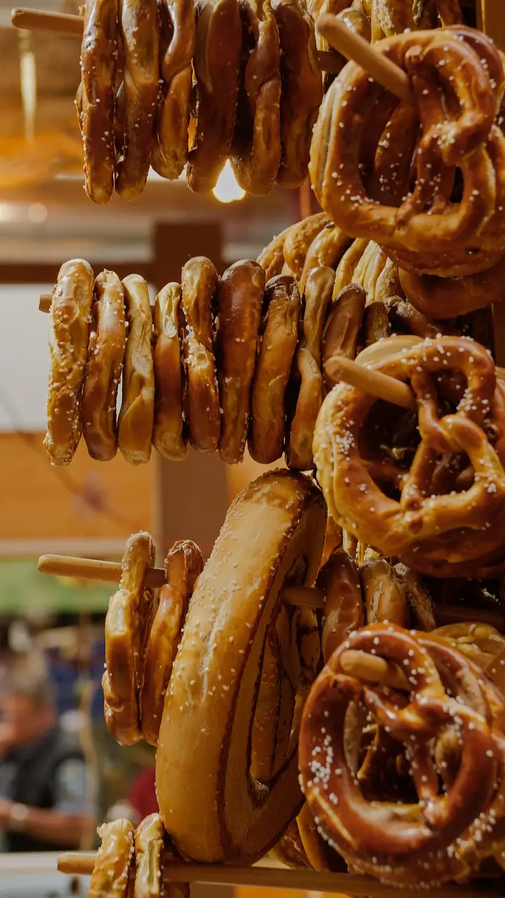 many golden soft pretzels on a wooden stand